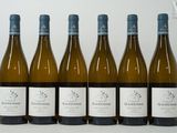 six bouteilles de vin sont alignées sur une table