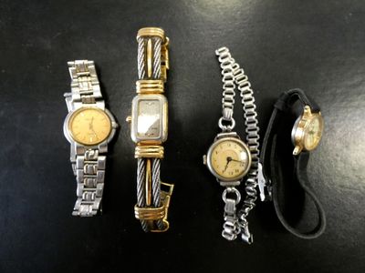 trois montres et un bracelet sont posés sur une table