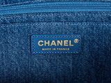 a close up of a blue chanel bag with a gold logo