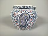 un vase orné d'un motif paisley, posé sur une table