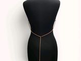 a black mannequin torso with gold chains and a gold necklace