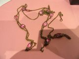 un collier rose orné de fleurs roses, posé sur un fond rose
