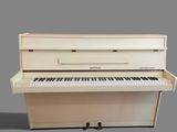 un piano blanc posé sur une surface grise