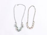 two silver necklaces on a white background with a white background
