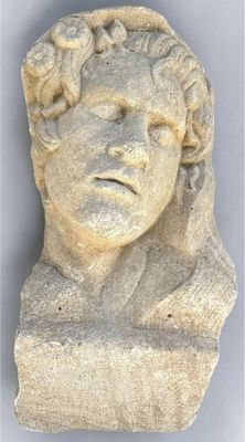 a close up of a statue of a man with a flower on his head