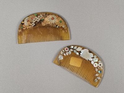 deux peignes en bois ornés de fleurs, posés sur une table