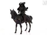 a statue of a man riding a horse on a white surface