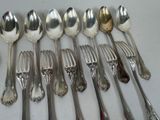 a lot of silver spoons and forks on the table