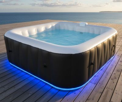 un jacuzzi gonflable installé sur une terrasse en bois donnant sur l'océan