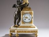 une petite horloge surmontée d'une statue