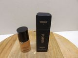 a bottle of liquid foundation foundation next to a box on a wooden table