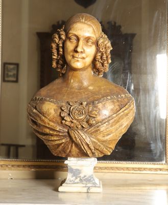 a bust of a woman sitting on a table in front of a mirror