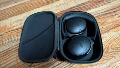 une photo représentant un casque audio dans son étui, posé sur un plancher en bois