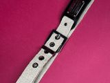 a close up of a wrist strap on a pink surface