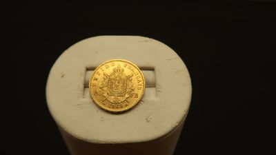 a gold coin sitting on top of a white object