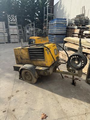 a yellow machine that is sitting in the middle of a pile of wood