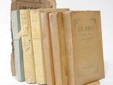 several old books stacked on top of each other on a white surface
