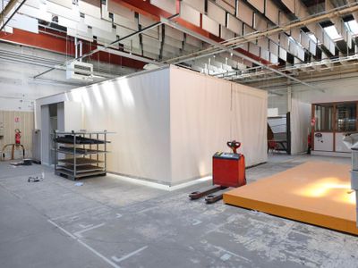 une grande pièce avec un mur blanc et une table rouge à l'intérieur