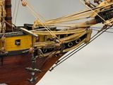 a wooden model of a ship on display on a table