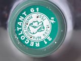 a close up of a bottle of water with a green cap