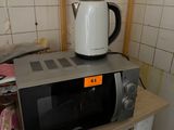 a microwave sitting on top of a shelf in a kitchen