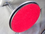 a red mirror sitting on top of a metal stand