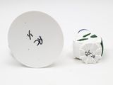 a white plate with a black writing on it next to a green and white ball