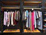 de nombreuses chemises suspendues à un portant dans un magasin de vêtements