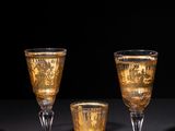 three wine glasses are sitting on a table with a black background