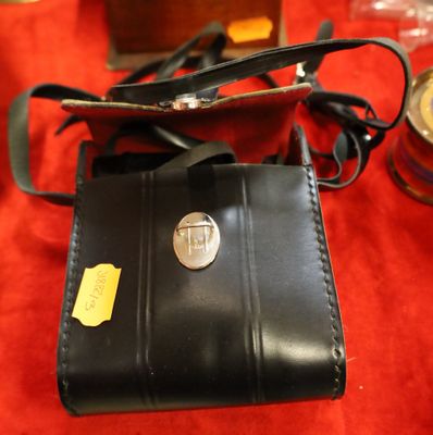 a small black wallet with a metal button on it