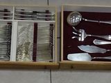 several spoons, forks and spoons in a wooden box on a wall