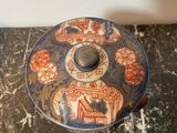 a small blue and red bowl on a marble table