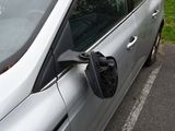 a silver car parked in a parking lot with its door open