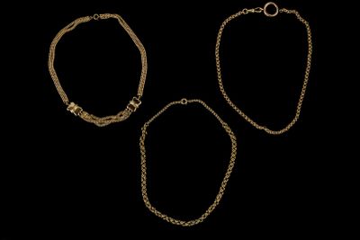 un ensemble de trois bracelets en or sur fond noir