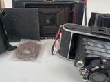 several old cameras are sitting on a white surface