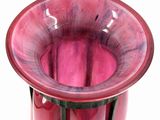 a red vase that is sitting on a white surface