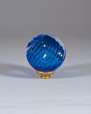 une boule de verre bleue posée sur un socle doré