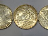 five oval shaped gold coins are lined up on a wall