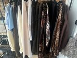 a lot of clothes hanging on a rack in a room