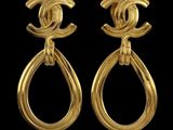 a pair of chanel earrings with gold tone