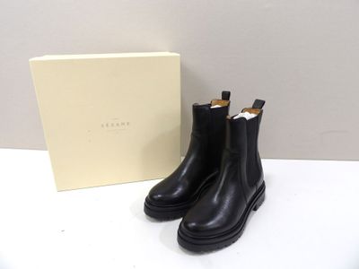 Les bottes noires sont à côté de la boîte, sur la table.