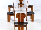 Plusieurs chaises et une table sont disposées en cercle sur une surface blanche.