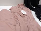 a pair of pink pants and a black shirt on a white table