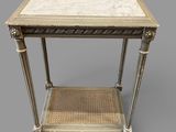 a white marble topped table with a wicker shelf underneath it