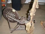 an old spinning machine in a garage with a trash can in the background
