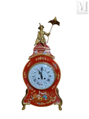 a red clock with a statue on top of it
