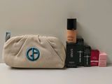 un petit sac orné d'un symbole de la paix bleu, posé à côté de quelques produits de beauté