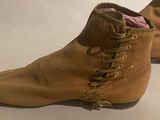 pair of brown shoes with laces on them sitting on a white surface