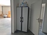 a refrigerator in the middle of a room with a lot of clutter on top of it