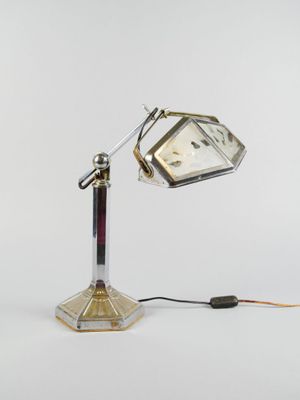 une lampe posée sur un pied sur lequel se trouve une horloge